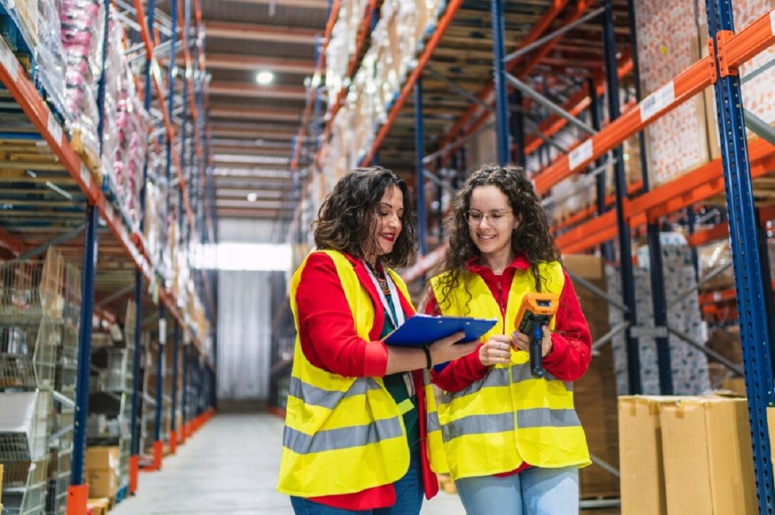 Two,Women,Wearing,Safety,Vests,Are,Managing,Inventory,In,A