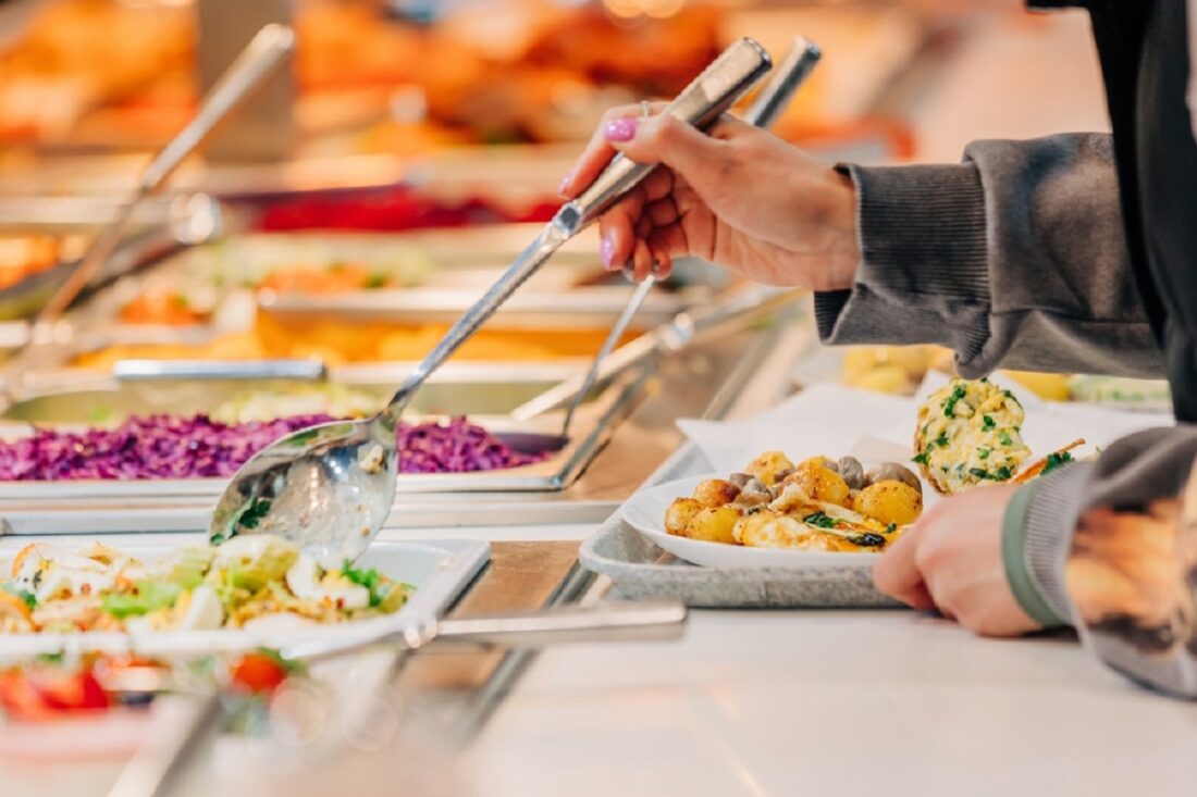 Woman,Puts,Food,On,Her,Plate,At,The,Buffet,,Closeup