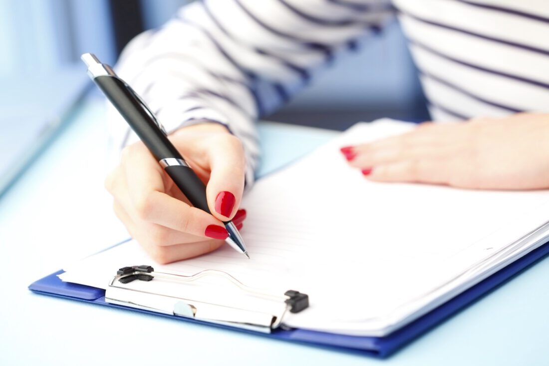 Close-up portrait of student fill the test while sitting at desk at university.