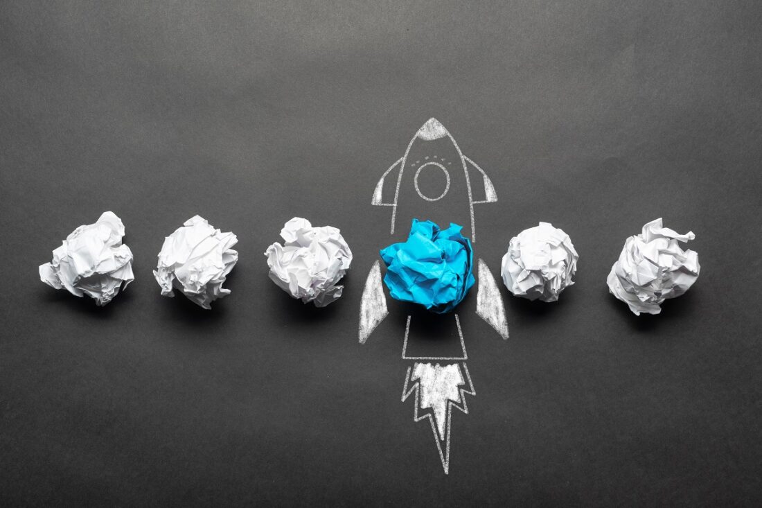 Rocket,Sketch,Drawing,With,Crumpled,Blue,Paper,Ball,On,Chalkboard.