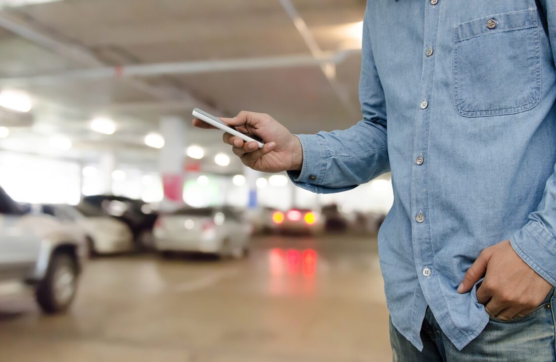 Casual,Young,Man,In,Blue,Shirt,And,Jeans,Using,Mobile