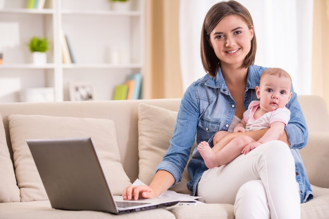 Young,Woman,Is,Working,From,Home,,Holding,Baby,Girl,On