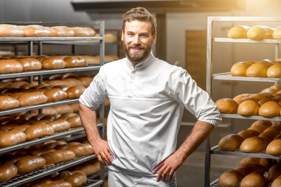 Portrait,Of,Handsome,Baker,At,The,Bakery,With,Breads,And