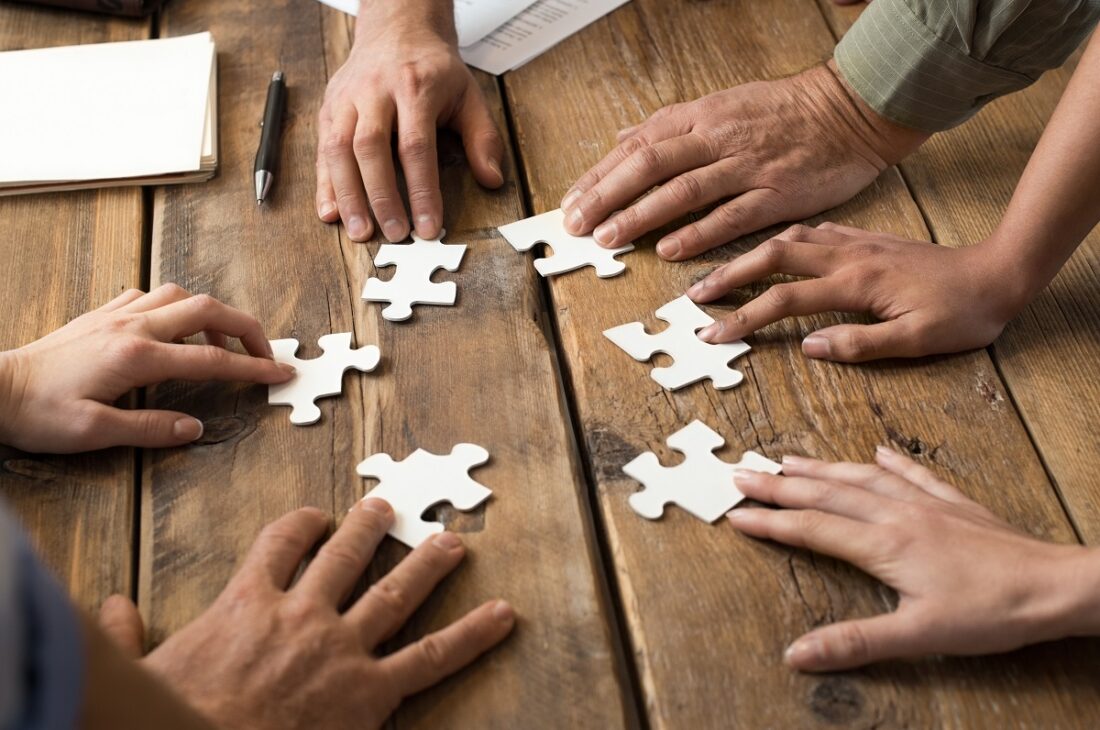 Closeup,Of,Businessman,And,Woman,With,Jigsaw,Puzzle,Pieces,In