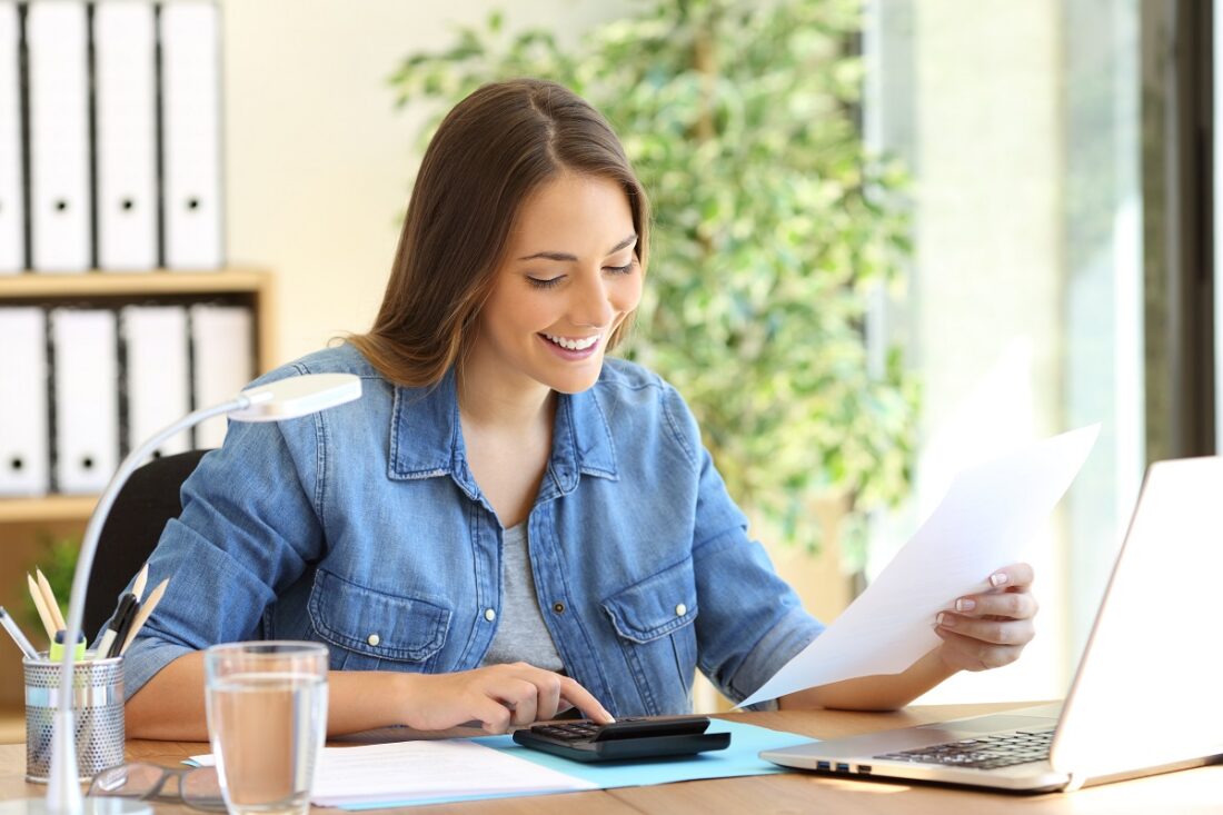 Freelance,Woman,Calculating,A,Budget,In,A,Desktop,At,Office