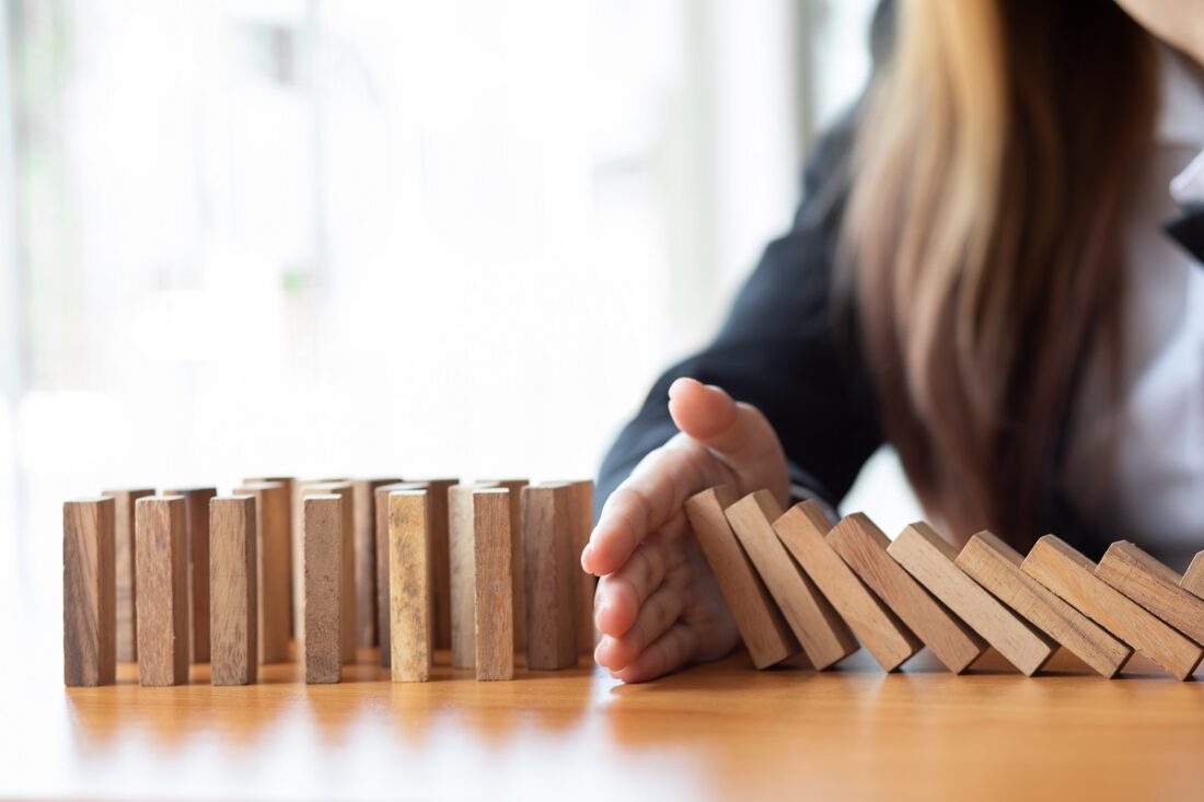 Businesswoman,Protect,Wooden,Block,Fall,To,Planning,And,Strategy,In