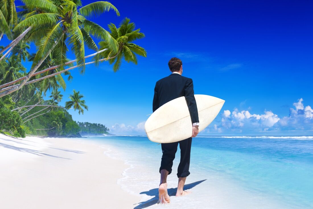 Businessman,With,Surfboard,On,Tropical,Beach