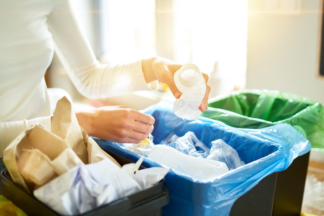 Woman,Putting,Empty,Plastic,Bottle,In,Recycling,Bin,In,The