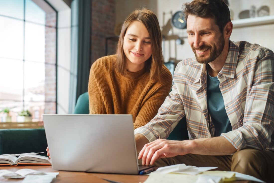 Doing,Accounting,At,Home:,Happy,Couple,Using,Laptop,Computer,,Sitting