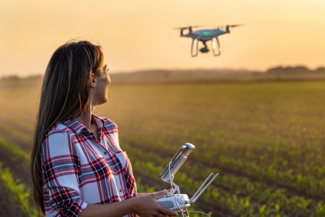 Pretty,Young,Farmer,Woman,Driving,Drone,With,Remote,Control,In