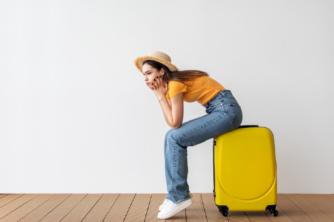 Air,Flight,Journey,Concept.,Sad,Woman,Sitting,On,Suitcase,,Waiting