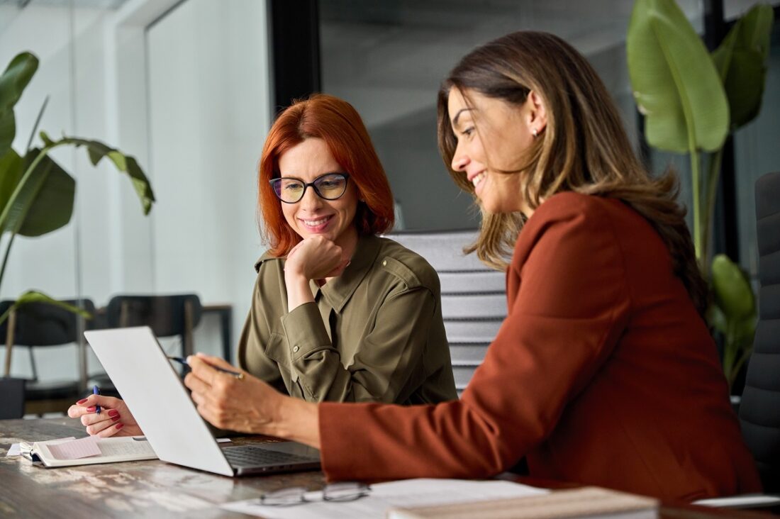 Two,Happy,Busy,Female,Employees,Working,Together,Using,Computer,Planning