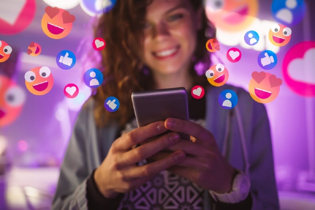 Happy,Young,Woman,Using,Her,Phone,To,Interact,With,Social